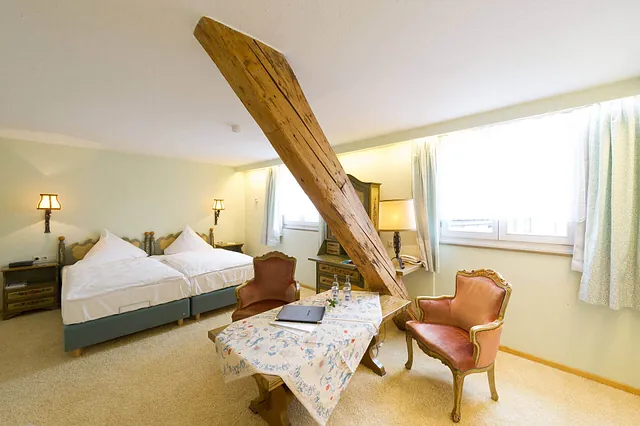 Helles Zimmer mit einem Holzbalken im Raum